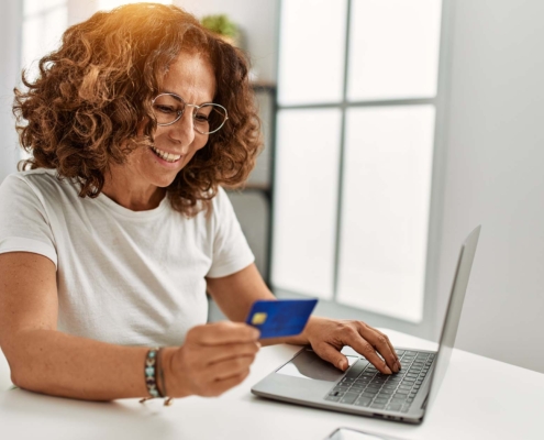 Person Looking At Payment Card Info At Laptop